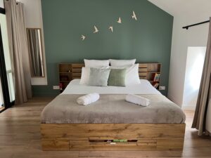 Chambre au deuxième étage d’une maison cabane à Cholet avec lit king size et décoration murale oiseaux