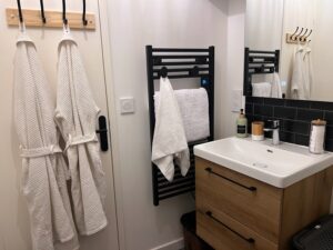 Salle de bain au deuxième étage d’une maison cabane à Cholet avec peignoirs