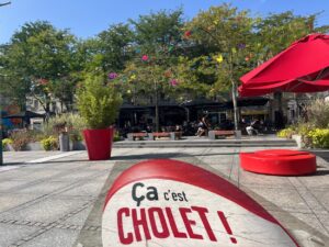 Place Travot à Cholet avec la brasserie Le Conti en arrière-plan et sticker « Ça c’est Cholet »