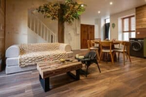 Pièce de vie chaleureuse de La Maison Cabane à Cholet avec canapé, arbre intérieur éclairé, table à manger et espace séjour.